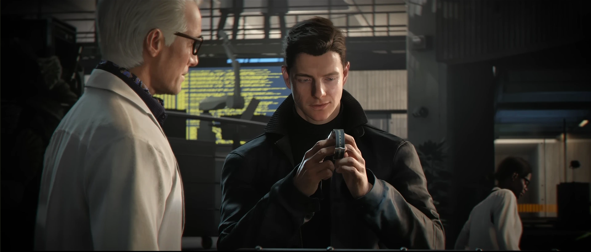 In 007 First Light, a young James Bond dressed in a dark coat intently examines a small silver device he holds. An older man in a light-colored lab coat and glasses stands to his left, observing him in a lab setting.