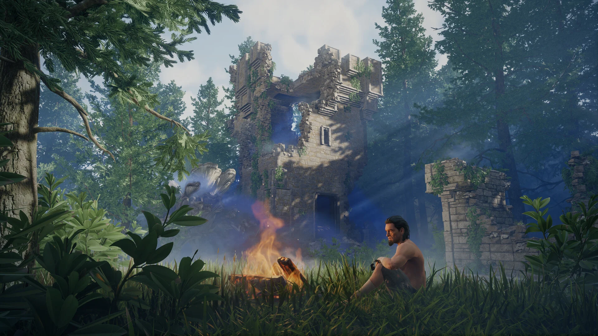 A detailed scene from the game Enshrouded, showing a male character with a beard sitting cross-legged next to a brightly burning campfire on a grassy patch. Behind him, a partially ruined stone tower, overgrown with vines, looms amidst tall green pine trees, with blue shroud emanating from its base.