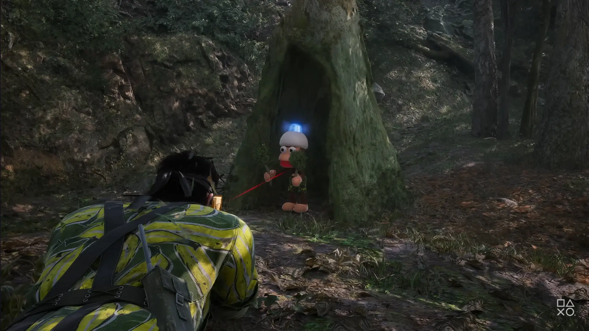 Gameplay screenshot from Metal Gear Solid Delta: Snake Eater, showing Snake in a jungle aiming at a Monkey from Ape Escape during the "Snake vs. Monkey" mini-game. The PlayStation button prompts are visible in the lower right corner.