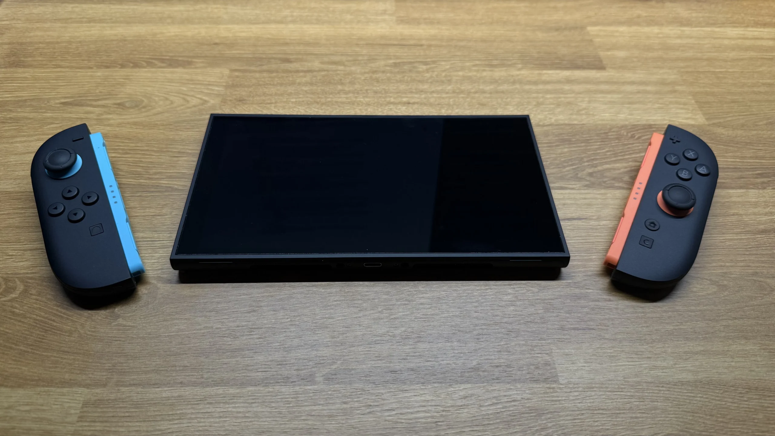 A disassembled view of the Nintendo Switch 2, showing the central tablet screen separated from its detached Joy-Con controllers.