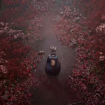 An overhead shot from Silent Hill f shows Hinako Shimizu, the protagonist, kneeling or crouching on a dark, narrow path. The path is surrounded by an overwhelmingly dense and vibrant array of red and pink foliage, creating a stark contrast against the dark ground. The foliage appears to be an unearthly, overgrown variety, contributing to the eerie and unsettling atmosphere of the scene.