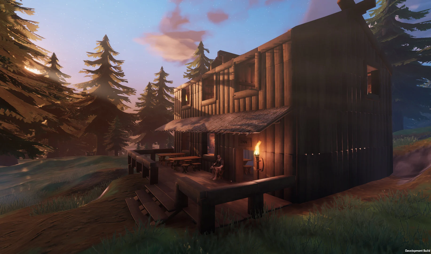 A large, two-story wooden Viking longhouse with a thatched roof, surrounded by pine trees, under a twilight sky in the game Valheim.