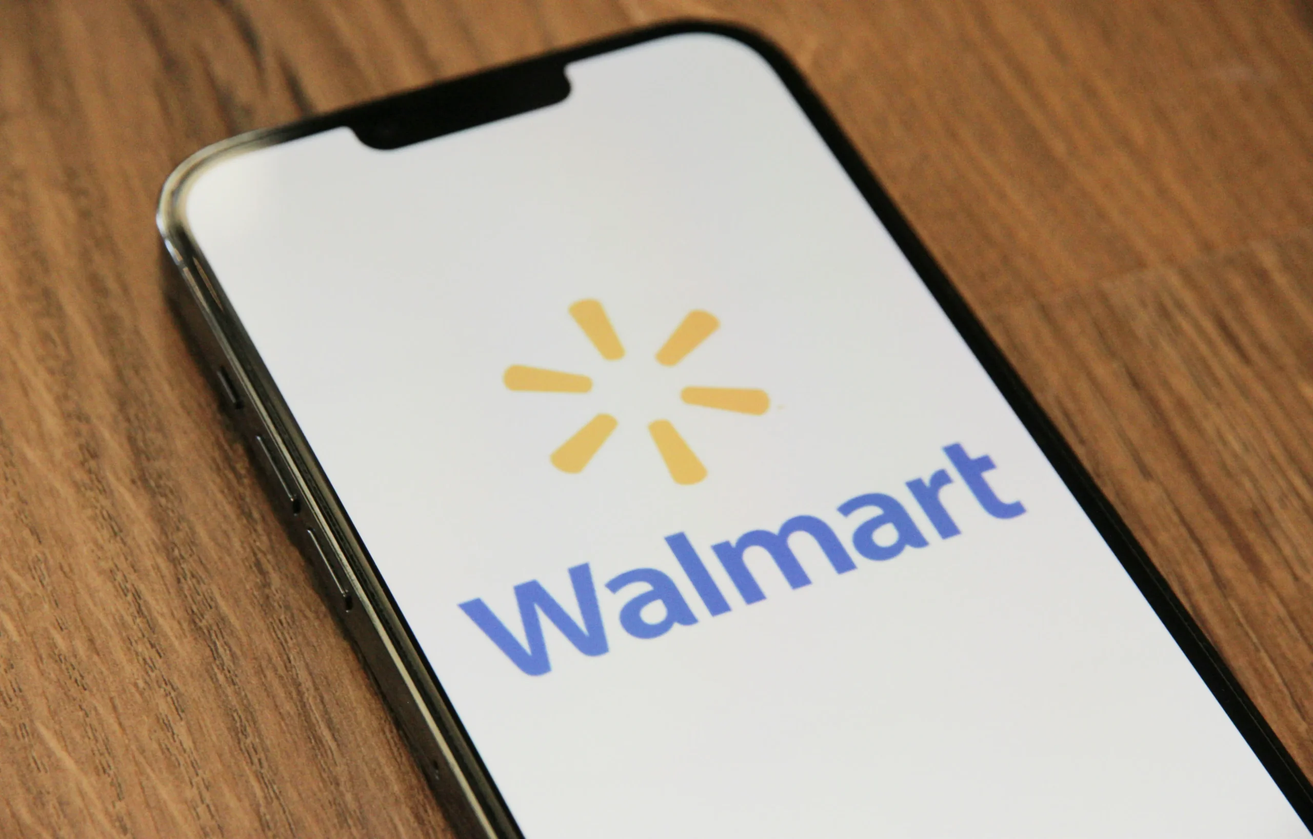 A close-up shot of a smartphone screen displaying the Walmart logo. 